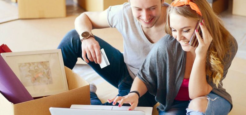 a couple is shopping something on a laptop
