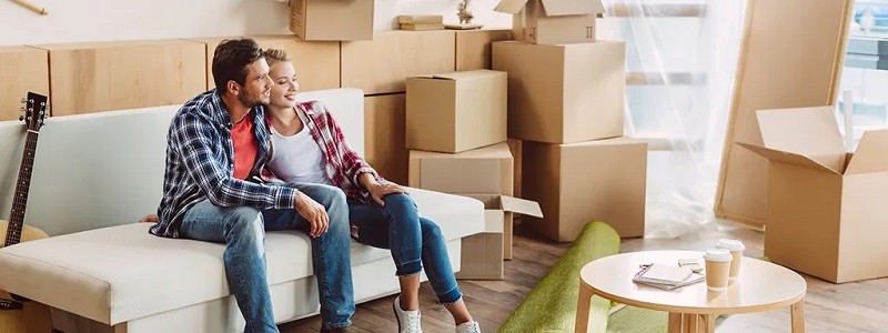 young couple sitting on a couch preparing for a relocation