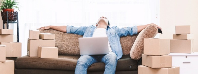 a young stressed man sitting on a couch with a laptop