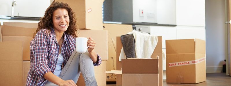 young woman sitting on the floor and holding a coffee mug