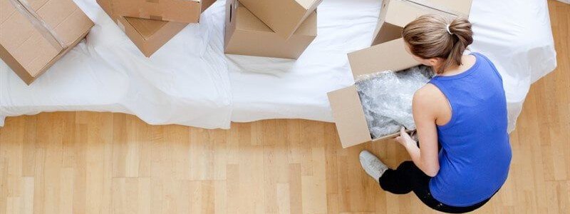 young woman packing household for a relocation