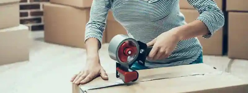 cropped picture of a woman packing a cardboard box