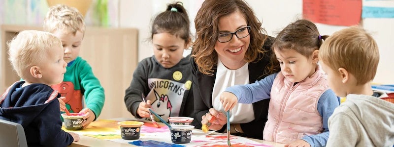 Teacher giving lesson about painting to the kids