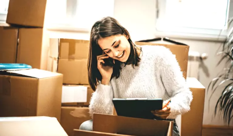 woman talking over a phone and looking at a tablet