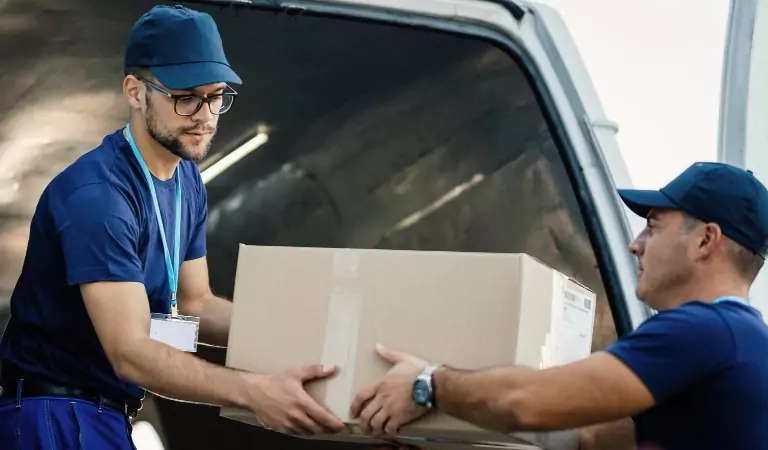 professionals loading a van with cardboard boxes