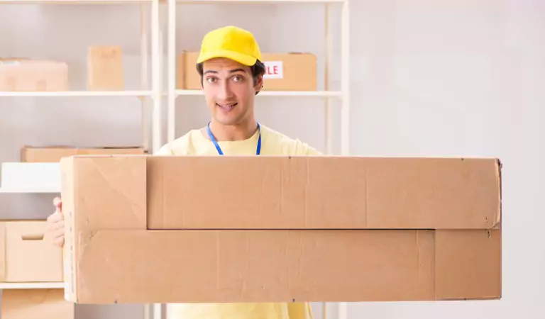 young professional holding a heavy cardboard box
