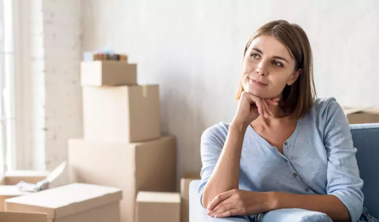 young woman sitting inside of her house and thinking of something