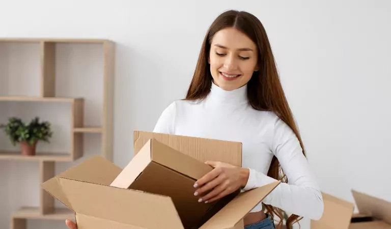 young woman unpacking a cardboard box