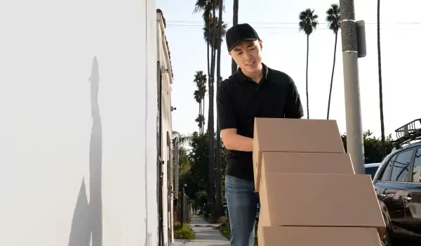 young man pulling a moving trolly with cardboard box