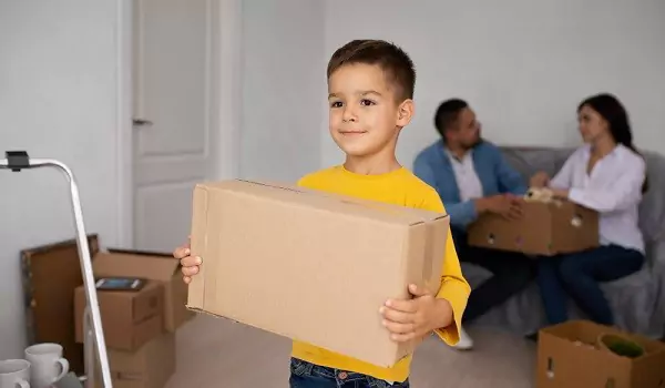 young kid with a cardboard box during a house move