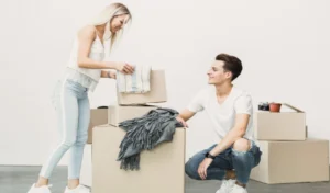 Young man and woman packing boxes